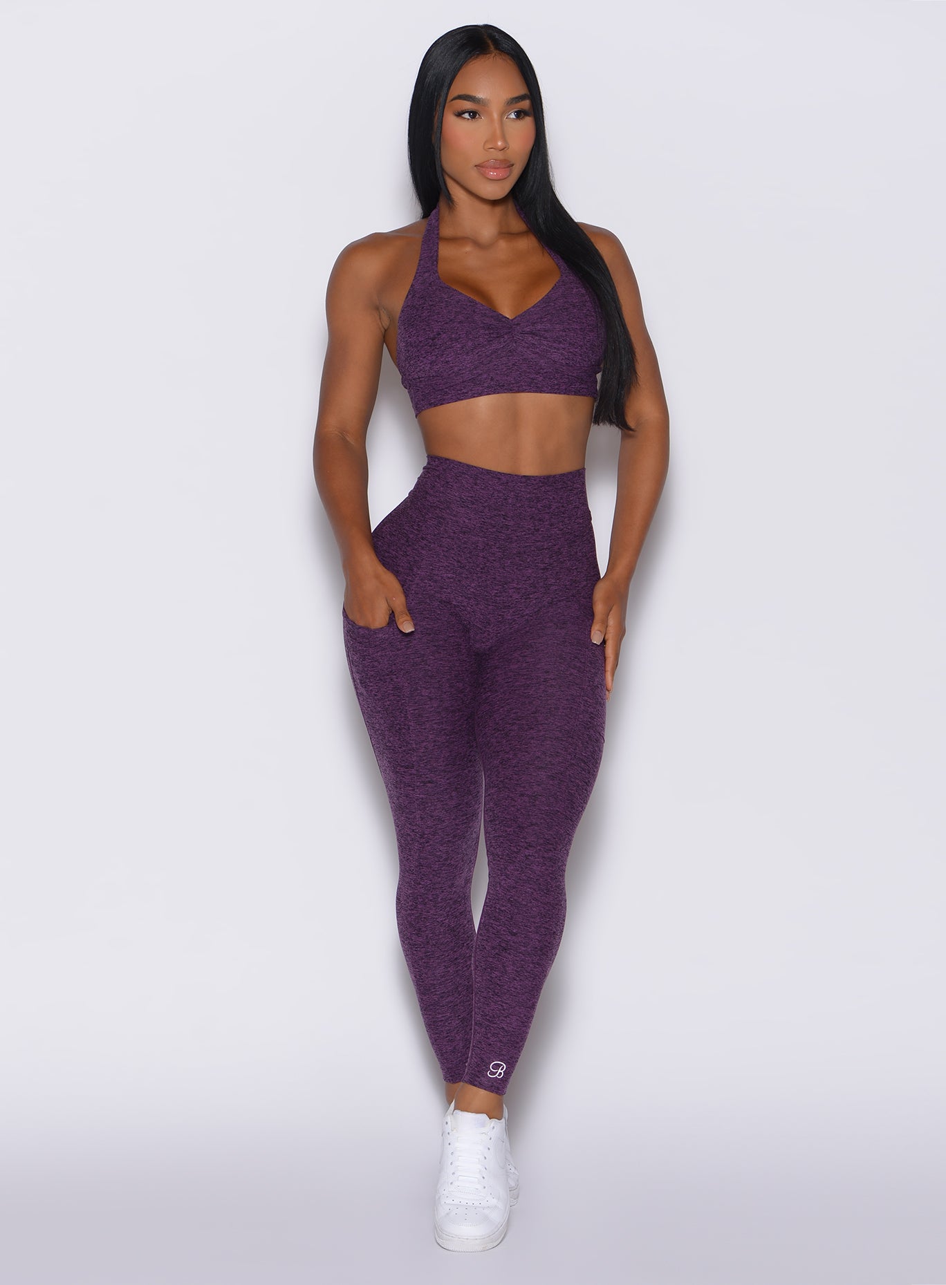 Model facing forward wearing our V back leggings in purple passion color and a matching bra 