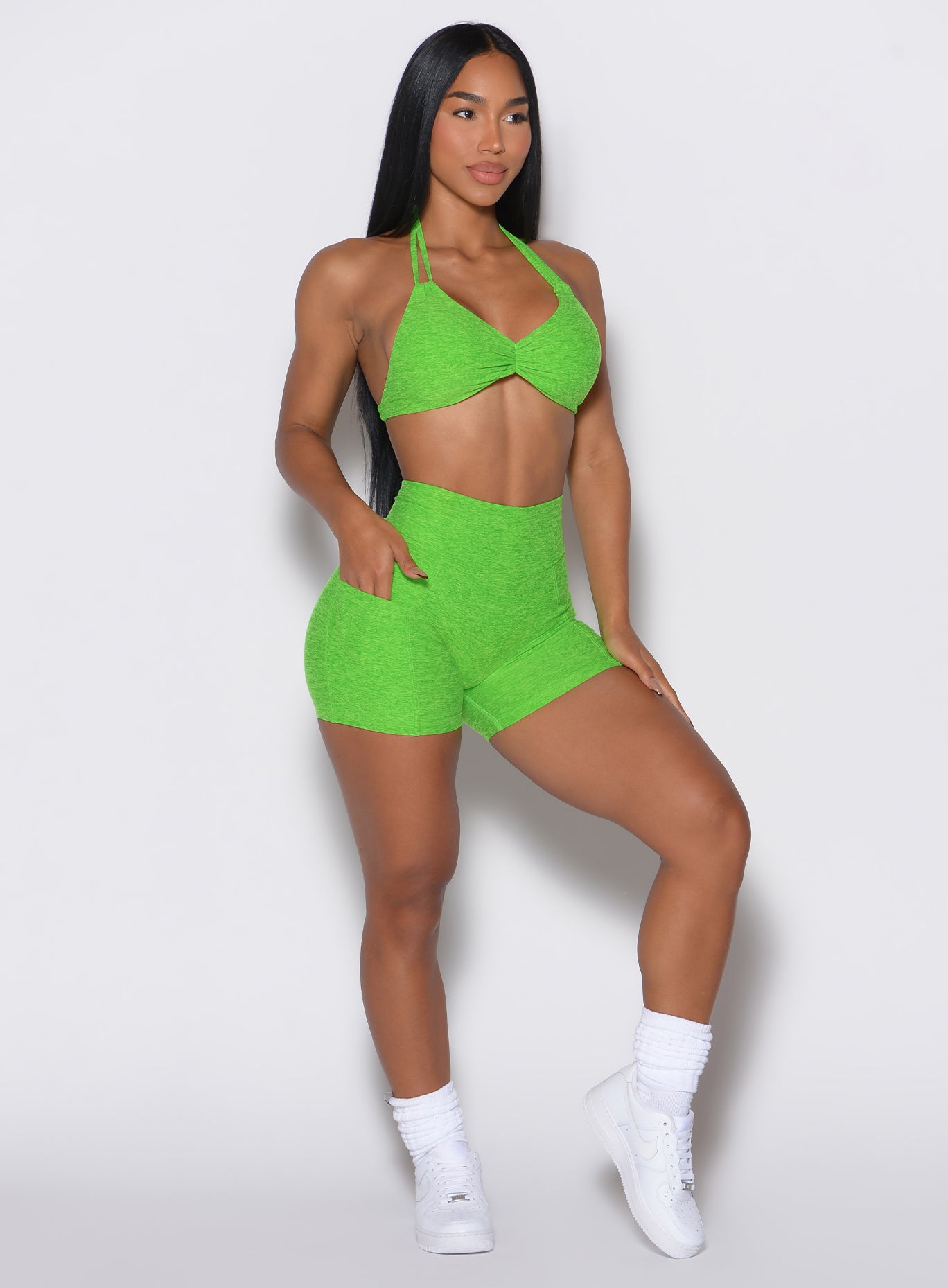 front profile picture of a model wearing our V back shorts in Neon Lime Green color along with the matching bra