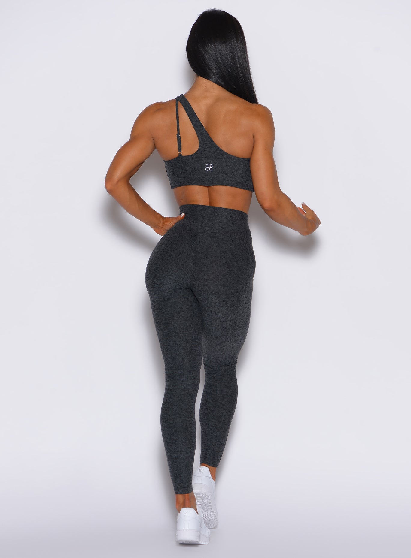 back profile view of a model wearing our V Active Leggings in charcoal color along with the matching top