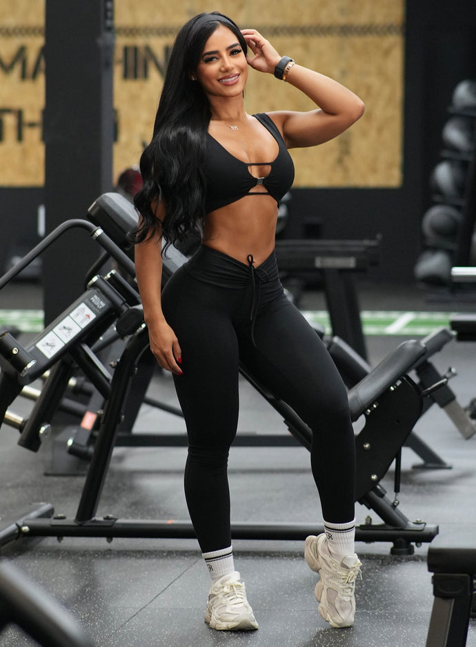 model at a gym wearing the Curvemax Leggings in Black color paired with the matching bra