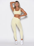 front profile view of a model wearing our V Seamless leggings in Mellow Yellow, complemented with the matching top