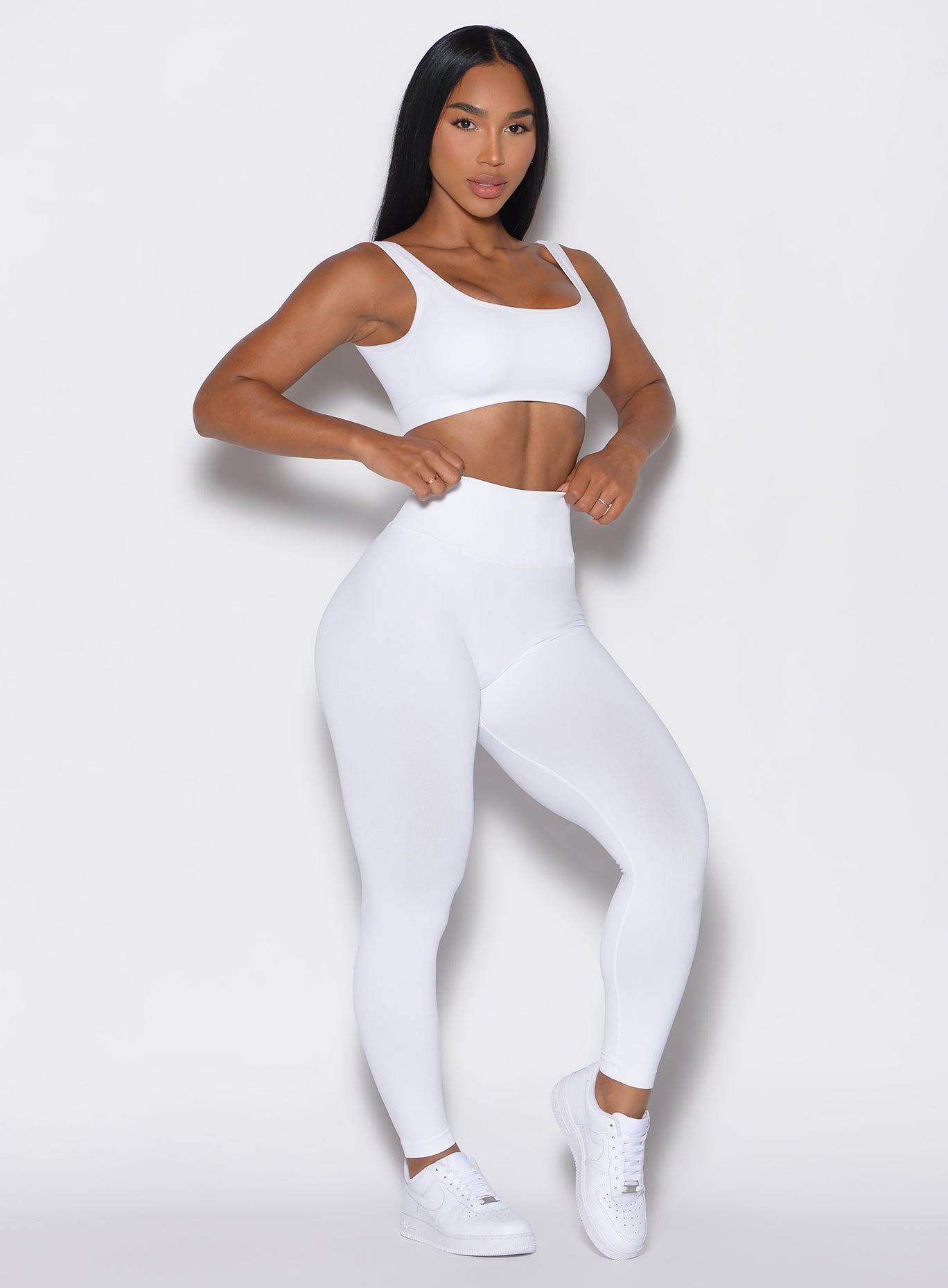 front profile view of a model wearing our white V Seamless Leggings along with a matching bombshell bra