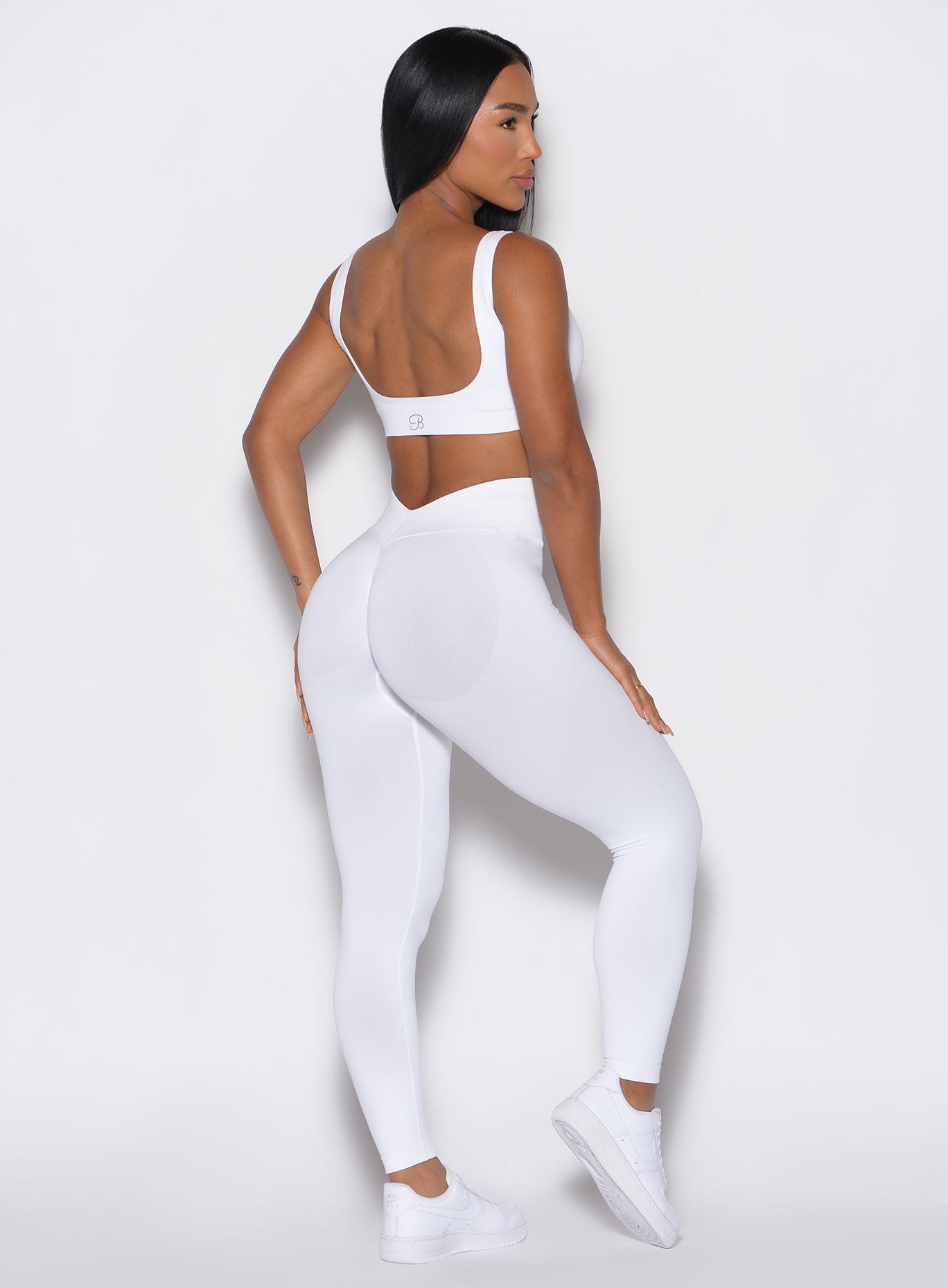 back profile view of a model wearing our white V Seamless Leggings along with a matching bra