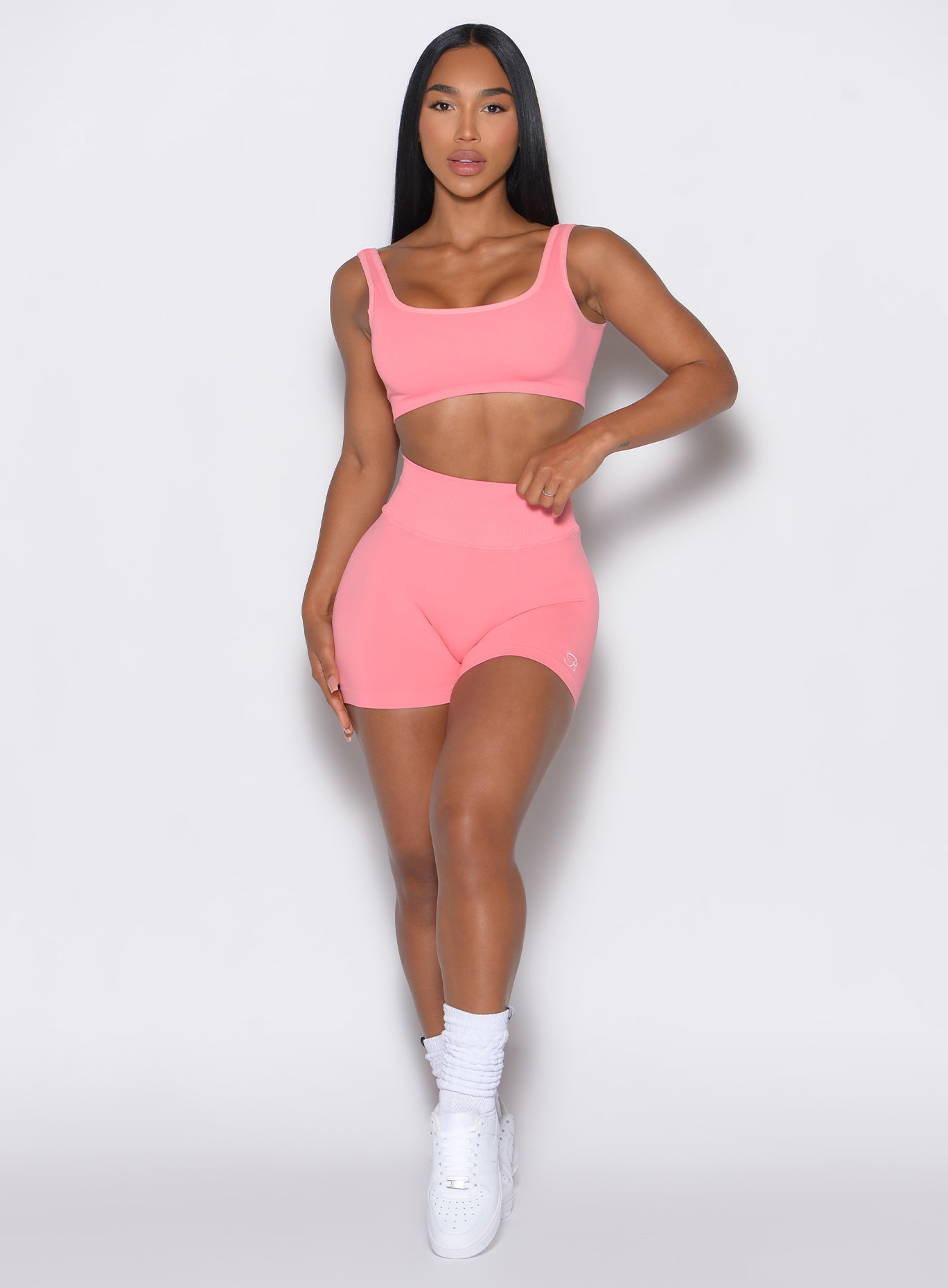 front profile picture of a model wearing our v seamless shorts in flamingo color along with the matching sports bra