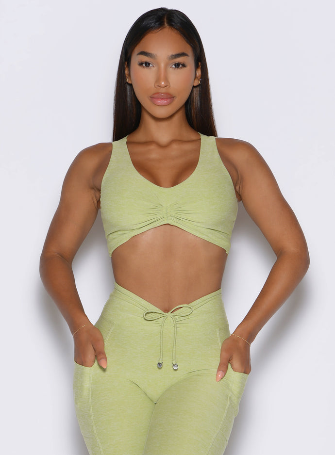 a frontal view of a model wearing the Two cute tank bra in Serpentine color paired with the matching leggings