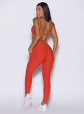 back side view of a model looking over her shoulder wearing the Wave Wire Leggings in firestorm color