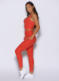 left side profile view of a model wearing the Wave Wire Leggings in firestorm color