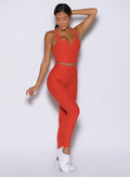 front profile view of a model wearing the Wave Wire Leggings in firestorm color paired with the matching tank 