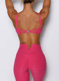 back side view of a model wearing the Wave wire bra in pink paradise color paired with the matching leggings 