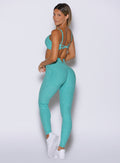 left side profile view of a model looking over her shoulder wearing the Wave Wire Leggings in Crystal current color