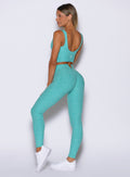 left side view of a model wearing the Wave Wire Leggings in Crystal current color paired with the matching top