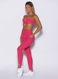 front left side profile view of a model wearing the Wave Wire Leggings in pink paradise color