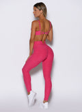 back left side profile view of a model facing to the left side wearing the Wave Wire Leggings in pink paradise color