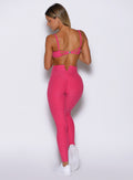 back profile view of a model facing to the left side wearing the Wave Wire Leggings in pink paradise color