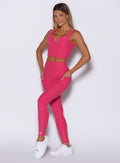 front profile view of a model with both hands inside the side pockets wearing the Wave Wire Leggings in pink paradise color