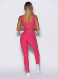 back profile view of a model wearing the Wave Wire Leggings in pink paradise color