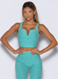 front profile view of a model with both hands on her waist wearing the Wave wire tank in Crystal Current color