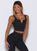 front profile view of a model wearing the Wave wire tank in heathered black color paired with the matching leggings 