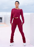 front profile view of a model in outdoors wearing the Luxe Leg Warmers in red velvet color