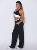 Bombshell Sportswear black lounge outfit right side angle with supportive halter bra and high-waist wide-leg cargo pants designed for flattering curves, second-skin comfort, and luxury active lounge style