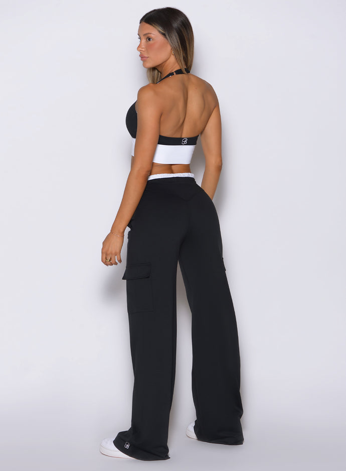Back view of model facing left, wearing Bombshell Sportswear wide leg joggers in Black color with relaxed flowy fit