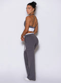 Left side profile view of a model wearing Bombshell Sportswear wide-leg cargo lounge pants, with side pockets and adjustable drawcord, designed for everyday wear