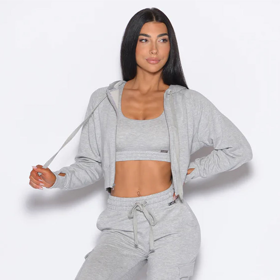 Light grey three-piece lounge set featuring a scoop sports bra, cropped hoodie, and joggers