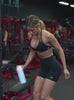 Video of a model working out wearing a black sports bra with matching fitted shorts.