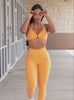 model in outdoors wearing the Uplift peach leggings in kumquat color paired with the matching bra 