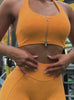 Video of a model wearing an orange sports bra with a front zipper and matching high waisted leggings.