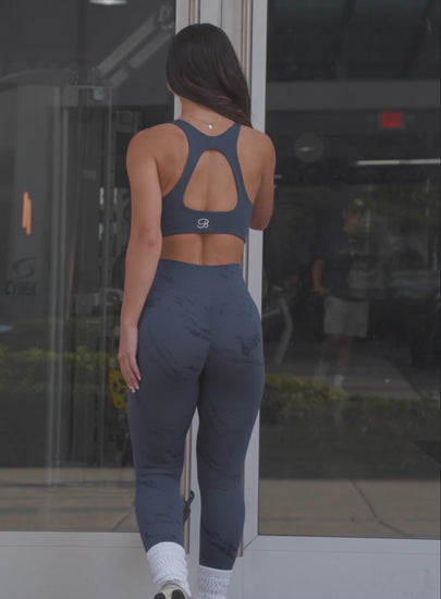 a short video of a model wearing our fit marble shorts in thunder gray color along with a matching sports bra