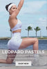 Video of a girl working out on a beach wearing a lavender leopard workout outfit in light purple. Text says "LEOPARD PASTELS no scrunch, no distractions. Just smooth sweat-ready fits with a wild side. SHOPW NEW"