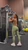 Video of woman wearing a green activewear bodysuit working out in a gym