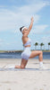 A video of a girl doing a stretching routine on the beach in our Leopard Baby Lavender gym outfit.