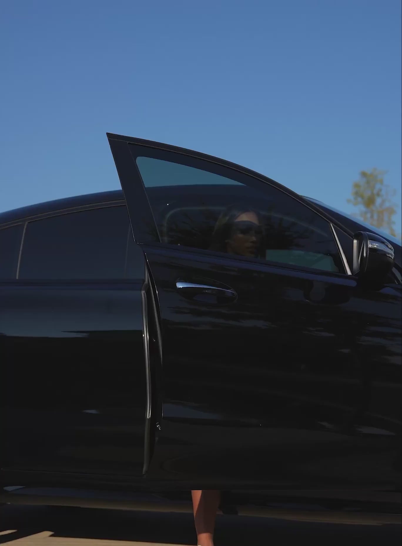 A short video of a model coming out of a car wearing the PowerFit Dress in blue slate color