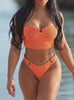 Close-up of a woman wearing a textured orange bandeau bikini set featuring gold ring details