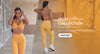 Model wearing a bright orange halter sports bra and matching high-waisted leggings from the "High Voltage Collection." Text on the image reads: “High Voltage Collection – Compressive fits and electric heathered hues made to power your movement.” A button below says “Shop New.”
