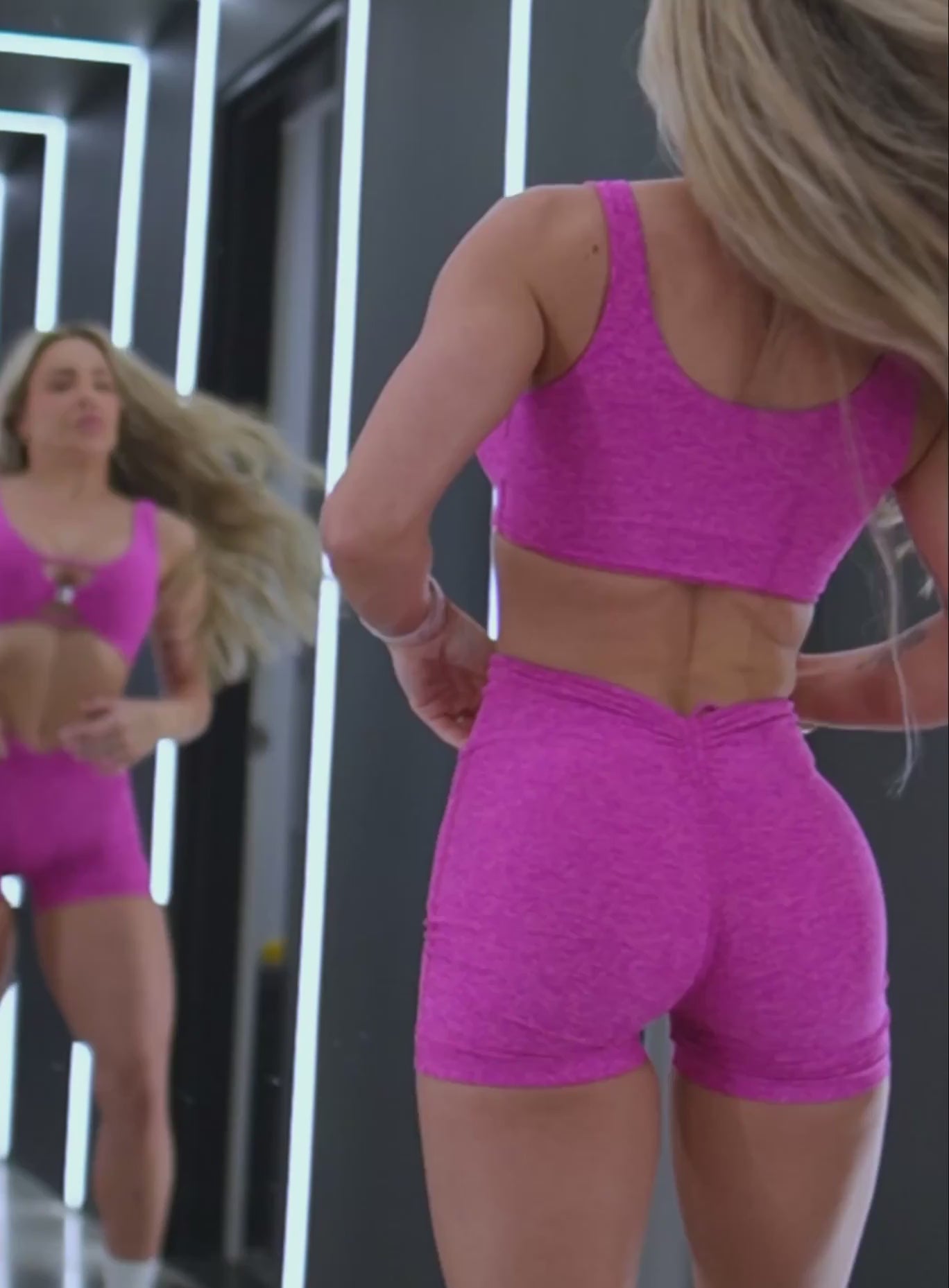 A short video showcase of a model in working out wearing the Curvemax Shorts in Neon pink sorbet color  paired with the matching bra