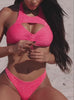 Close-up of a woman adjusting a sparkly hot pink bikini with a high-neck keyhole top and ruched center, paired with matching bikini bottoms.