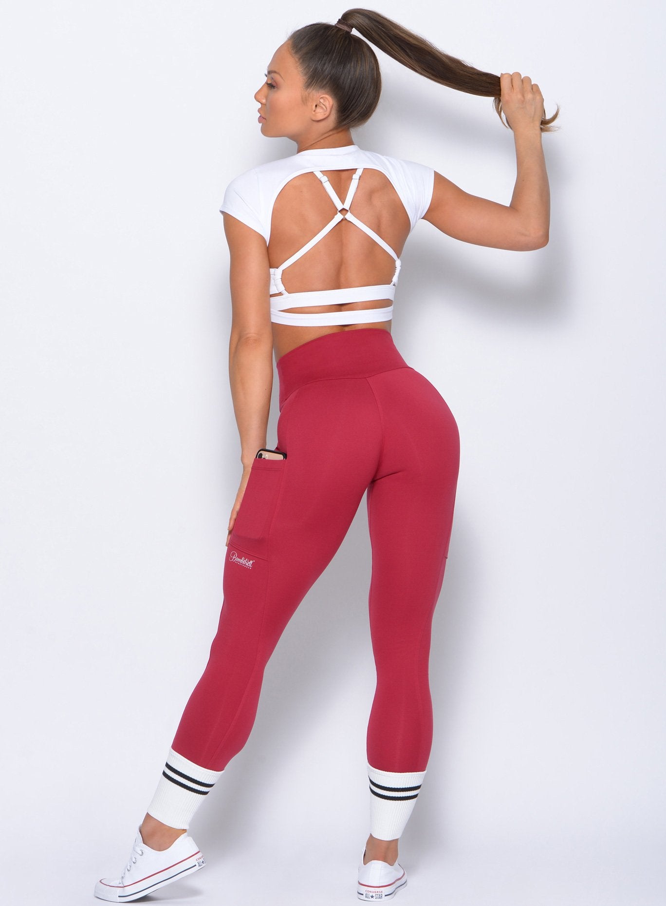 Full back view of the model in the Ankle Sock Leggings in maroon color with 2 black stripes