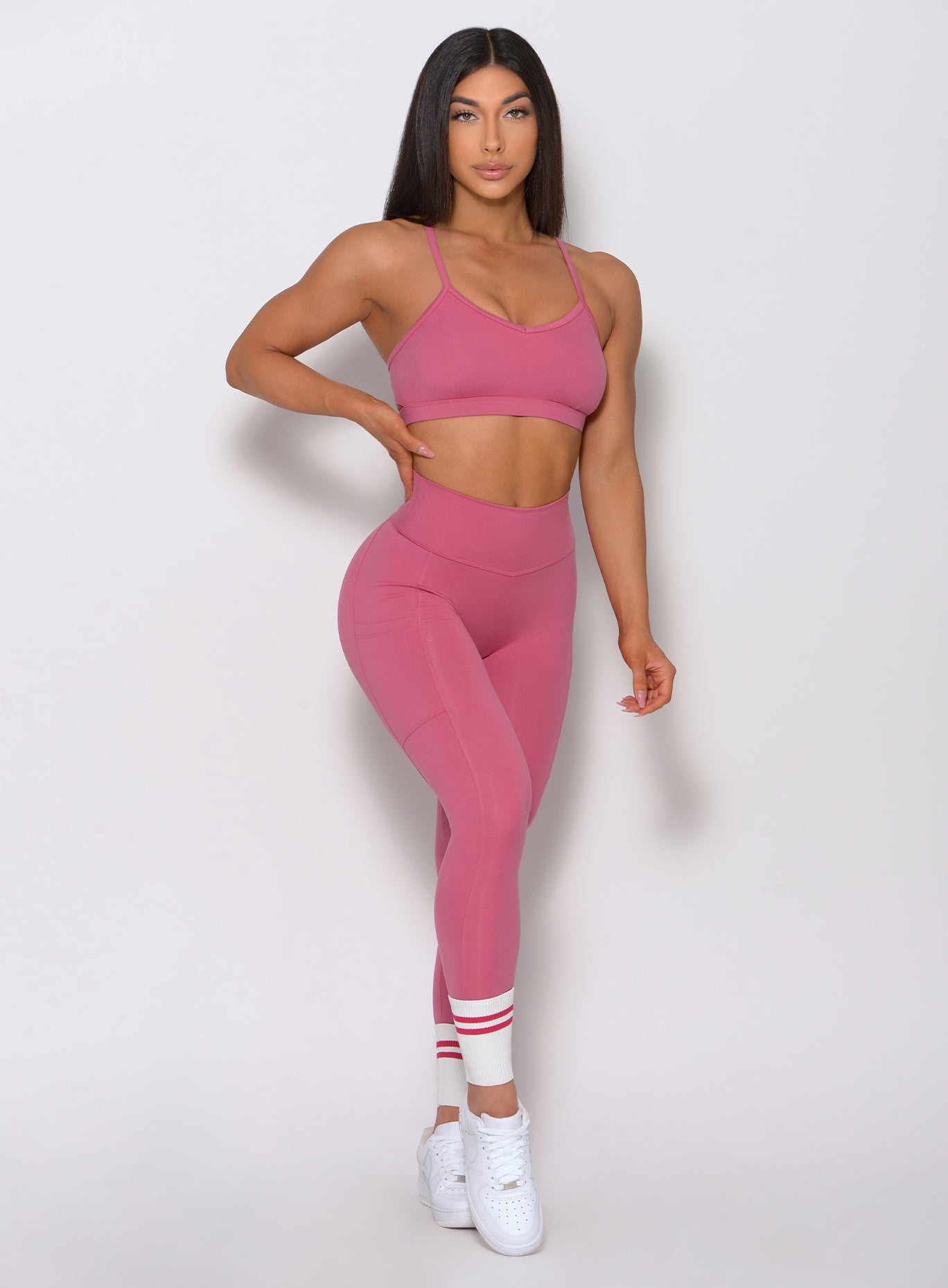 Full front view of the model wearing our pumped sports bra in blush color and a matching high waist leggings