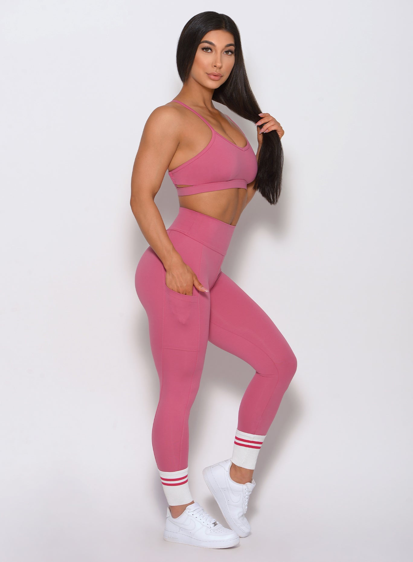 Right side view of the model wearing our ankle sock leggings in blush color and a matching bra