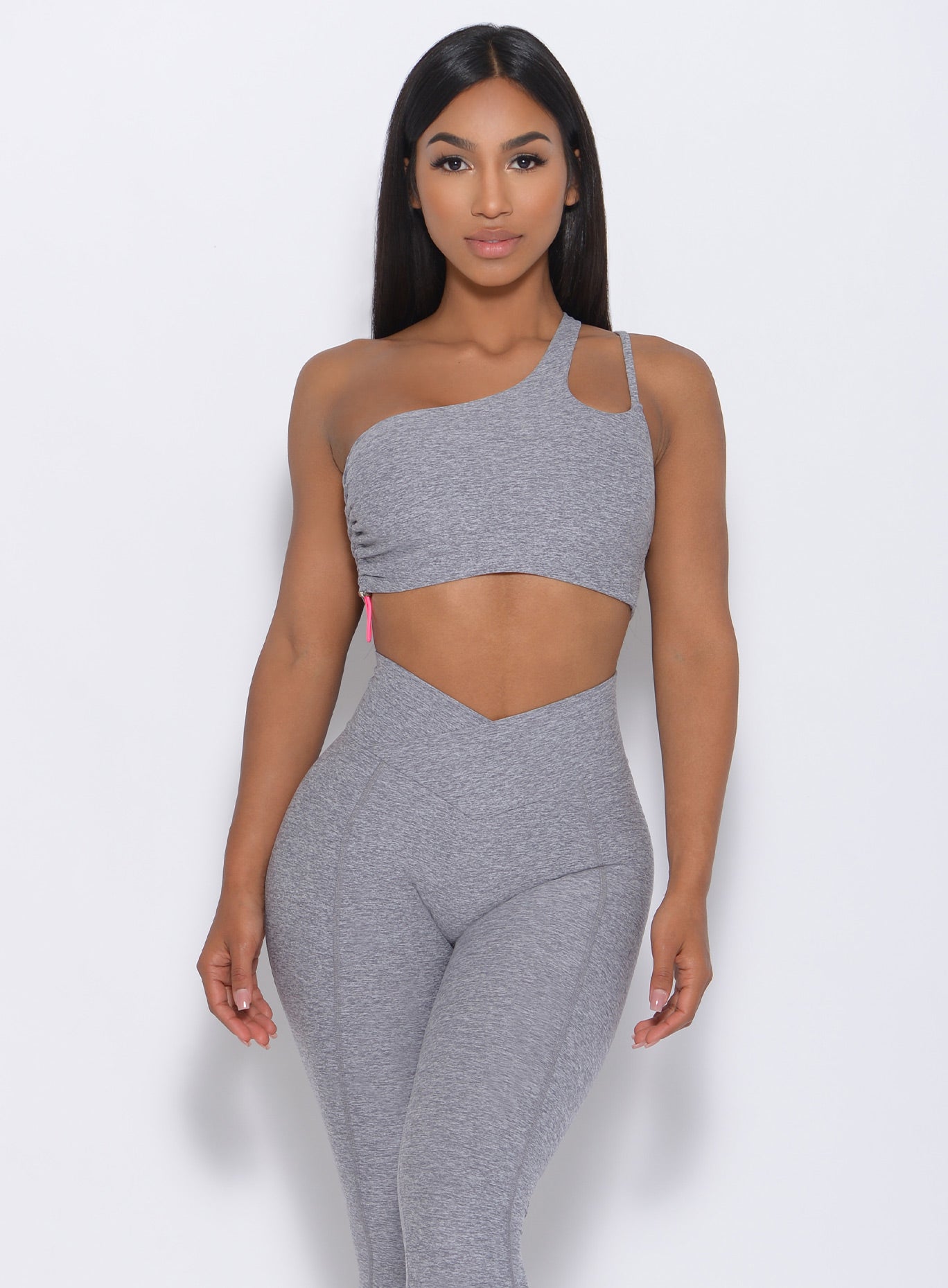 Model facing forward wearing our asymmetrical scrunch bra in cloud color and a matching leggings