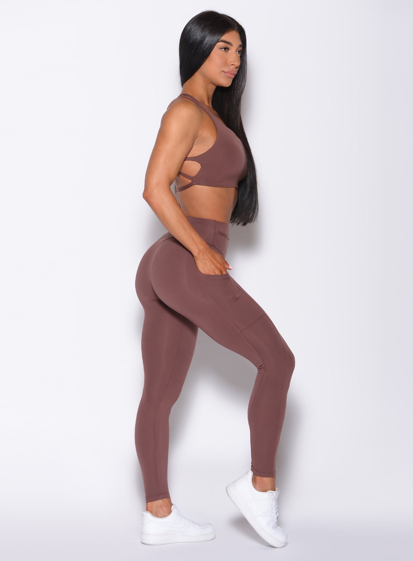 Right side profile view of a model in our barbell leggings in chocolate color and a matching bra