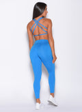 Back profile view of a model wearing our barbell leggings in crystal pop blue color and a matching bra