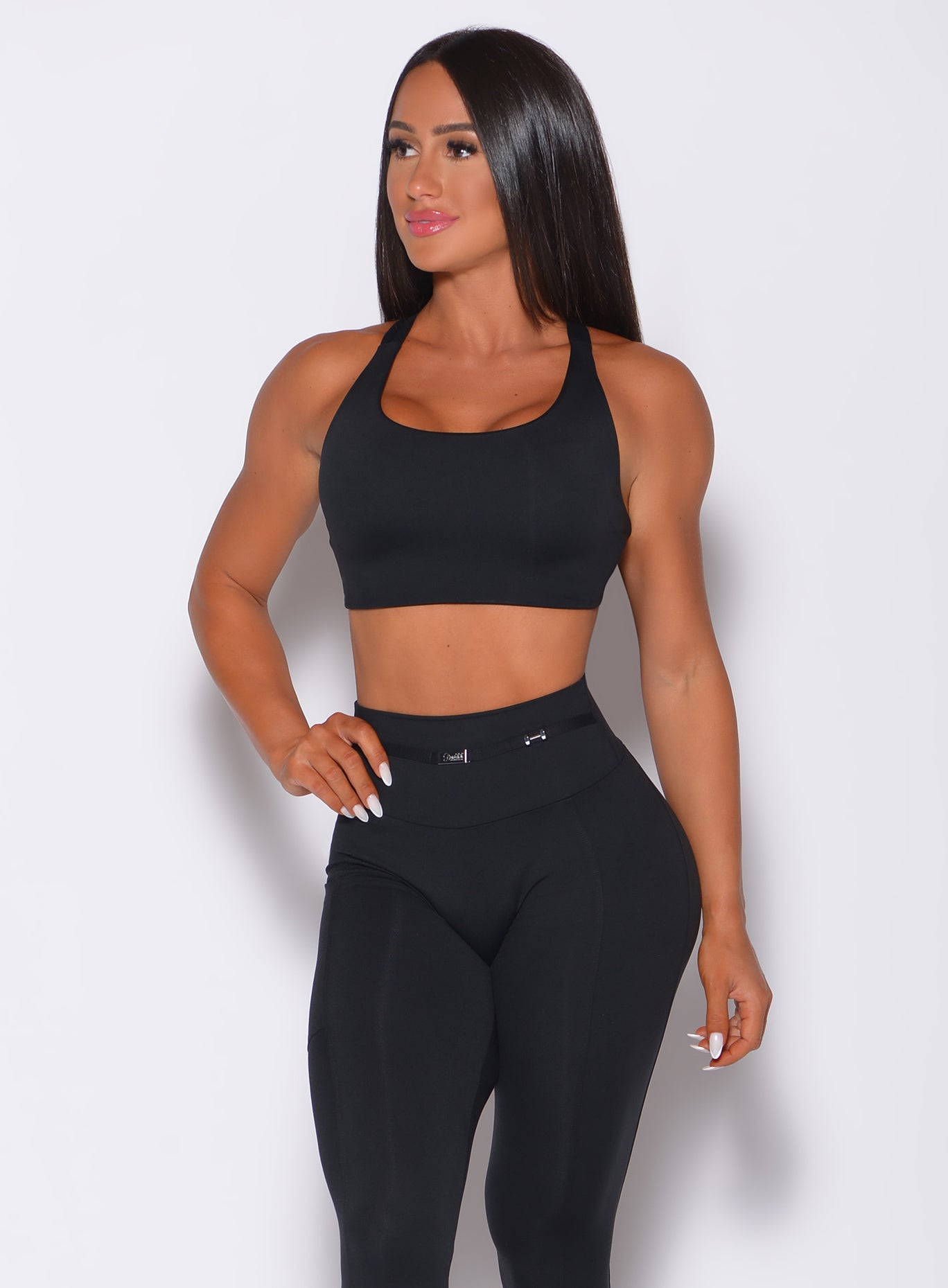 Front profile view of a model in our black barbell sports bra and a matching leggings