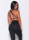 Back profile view of a model in our black barbell sports bra and a matching leggings 
