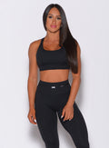 Front profile view of a model wearing our black barbell sports bra and a matching leggings