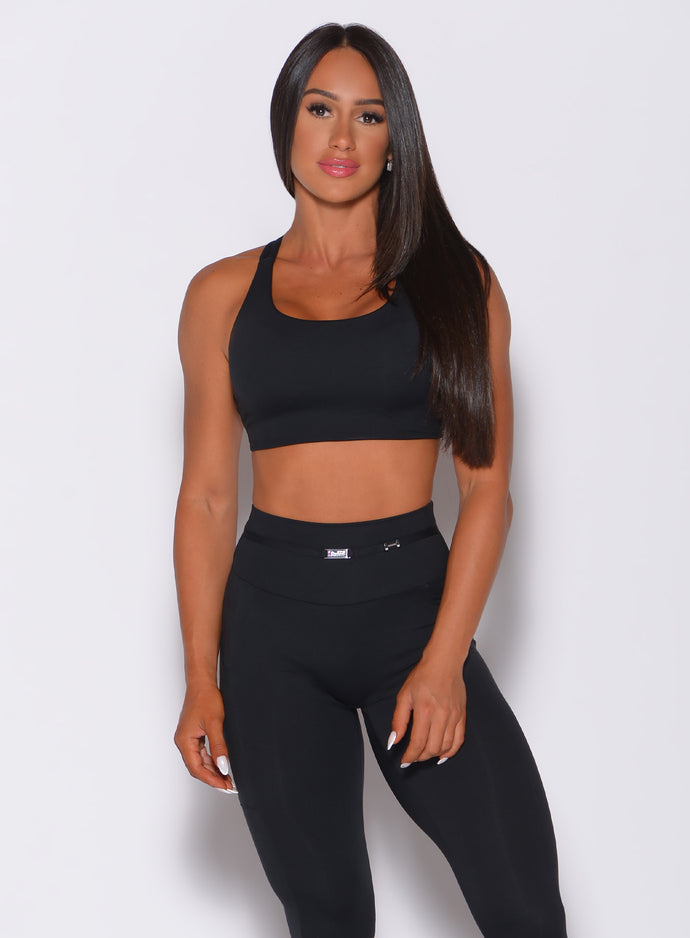 Front profile view of a model wearing our black barbell sports bra and a matching leggings