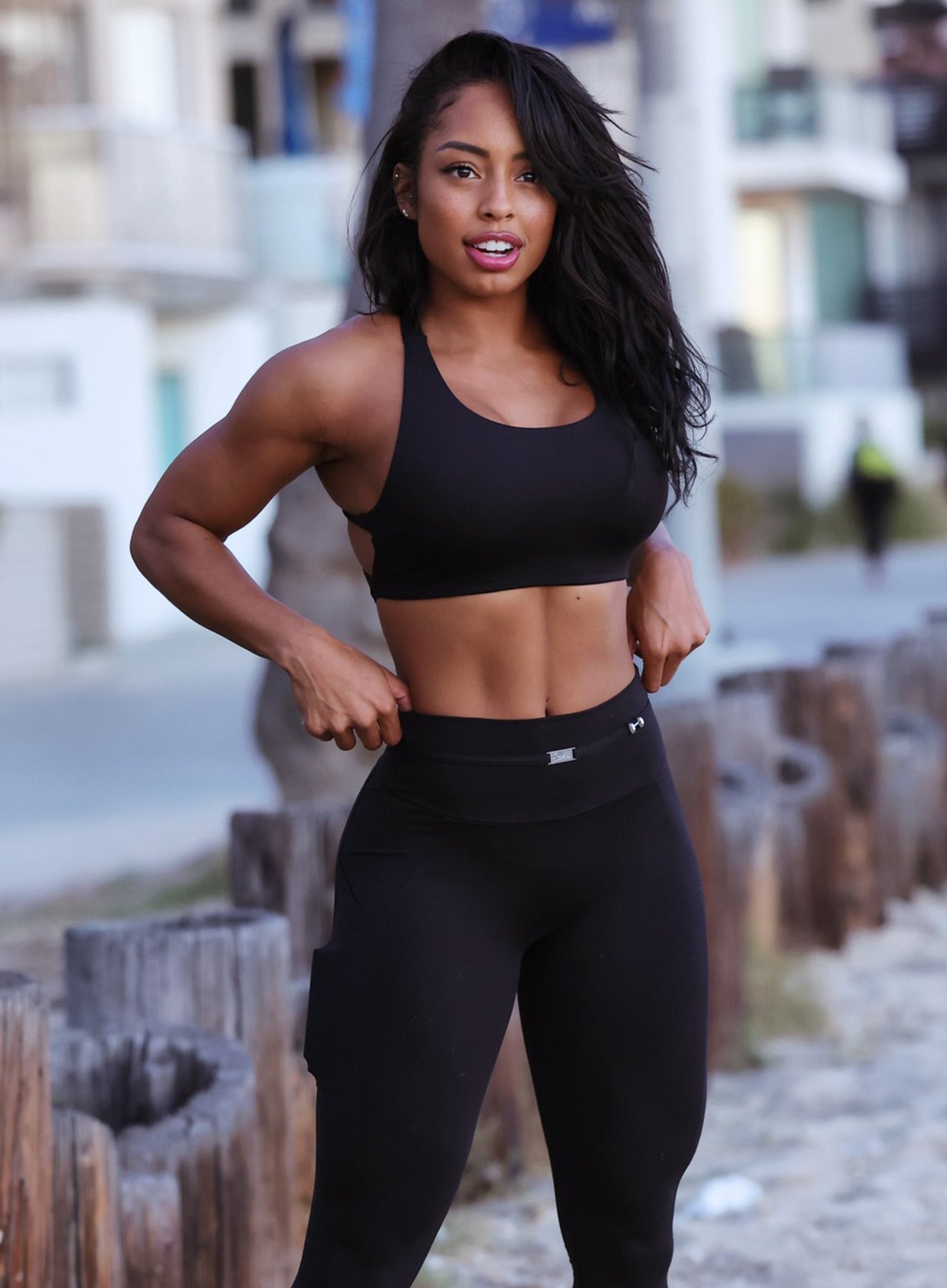 Front profile view of a model wearing our black barbell sports bra and a matching leggings